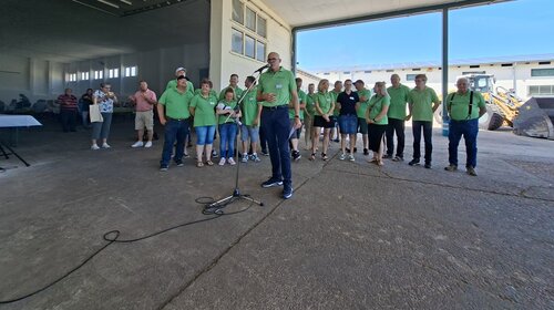Mitarbeiter des Standortes Abtsbessingen stehen versammelt an einem Platz. Davor hält Vorstand Mark Woestmann die Eröffnungsrede.