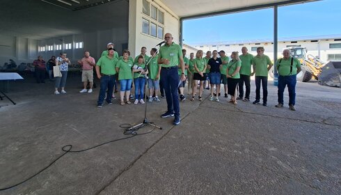 Mitarbeiter des Standortes Abtsbessingen stehen versammelt an einem Platz. Davor hält Vorstand Mark Woestmann die Eröffnungsrede.