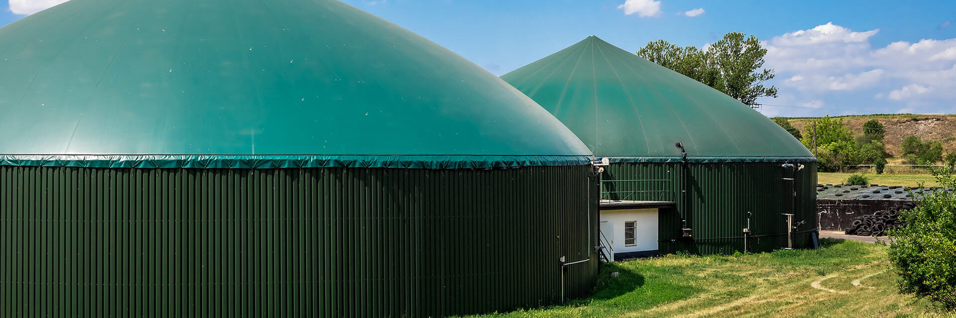 Zwei moderne Biogasanlagen zur nachhaltigen Energieerzeugung in einer grünen Landschaft.